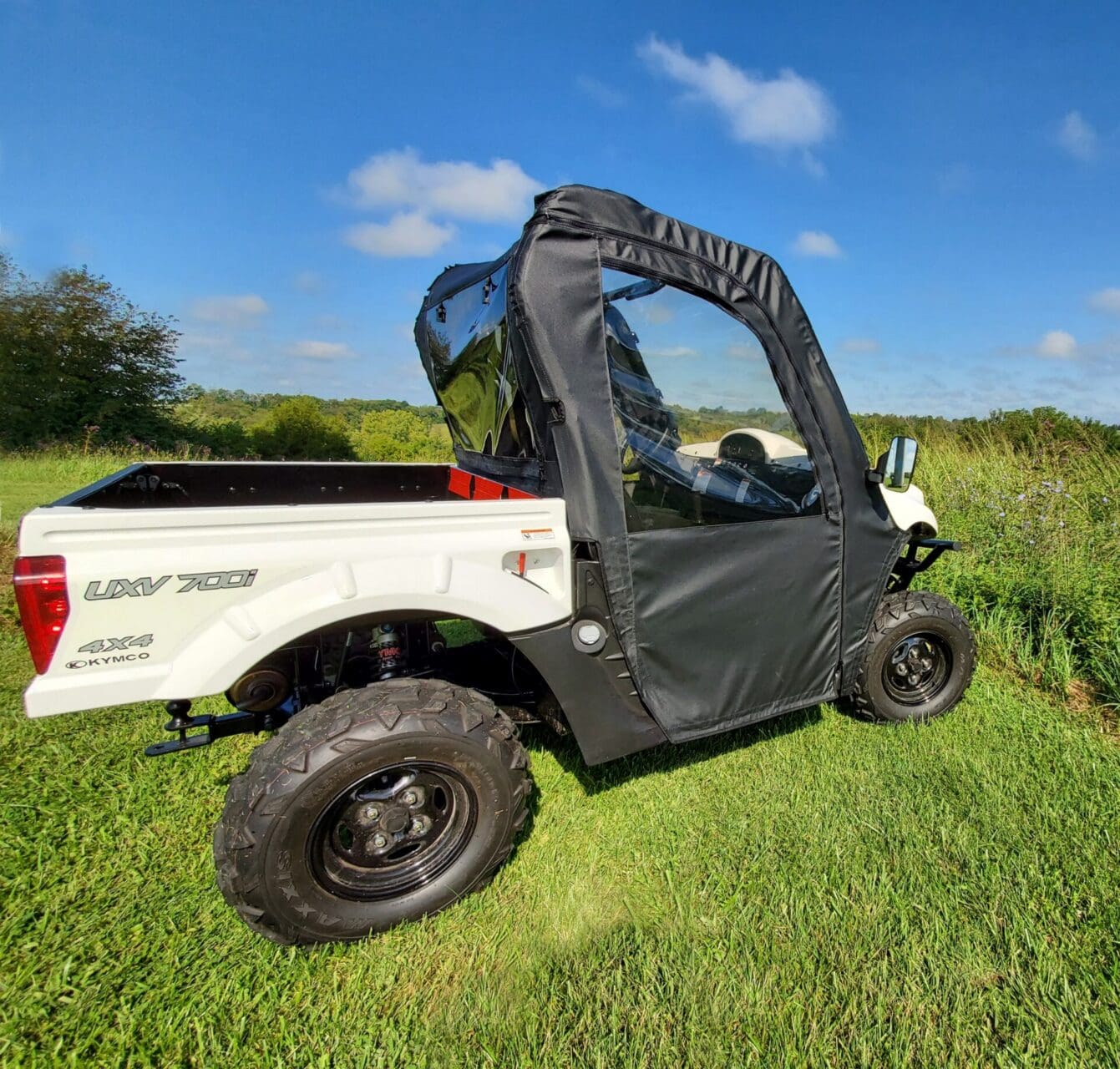 Utility vehicle with soft enclosure in field.