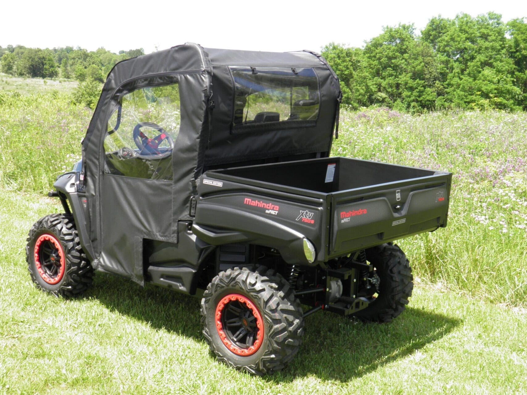 Mahindra utility vehicle with soft enclosure outdoors.
