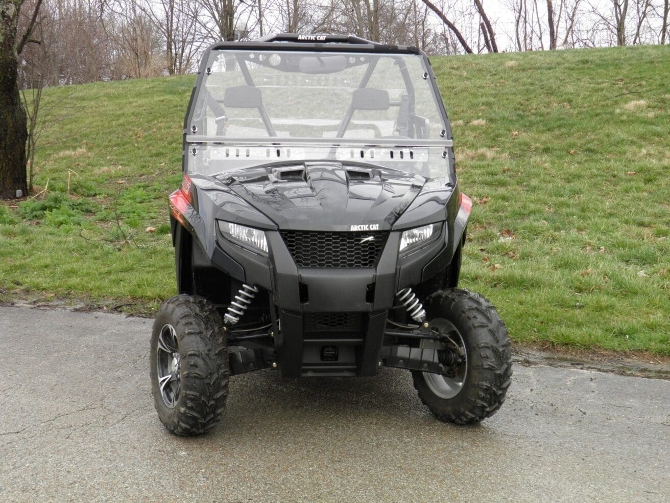 Black Arctic Cat UTV parked on pavement