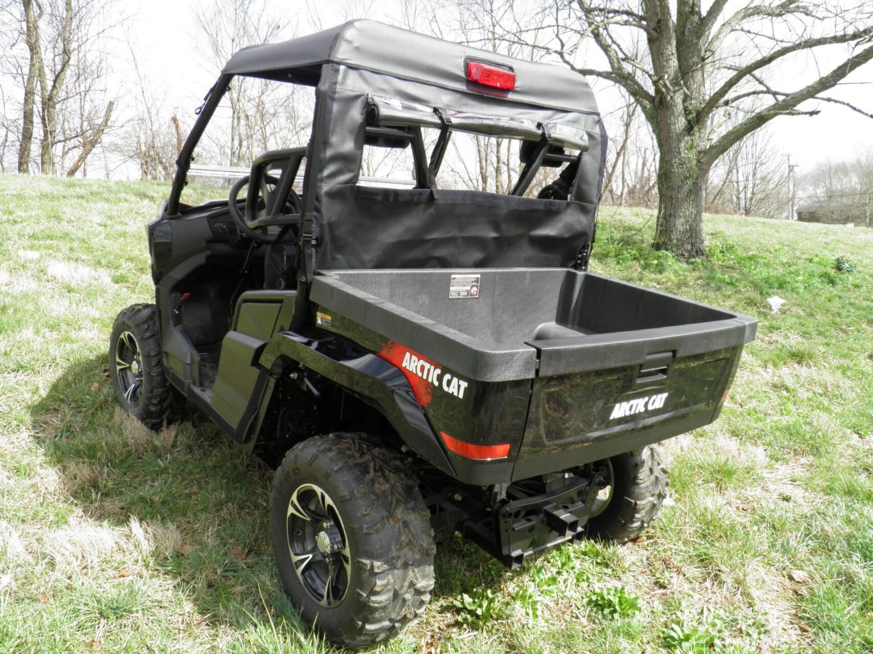 Black Arctic Cat UTV parked on grass