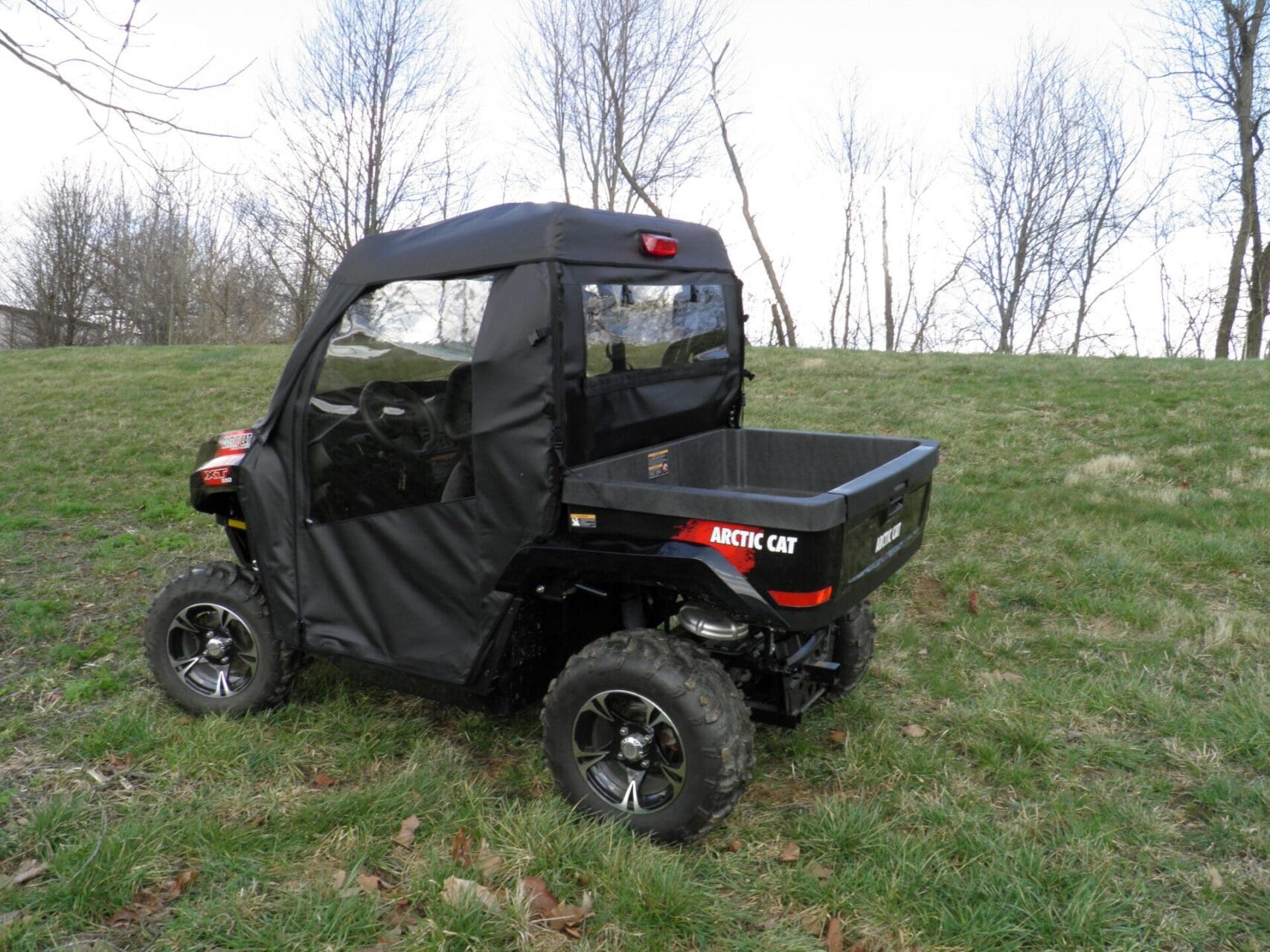 Black Arctic Cat UTV on grassy field