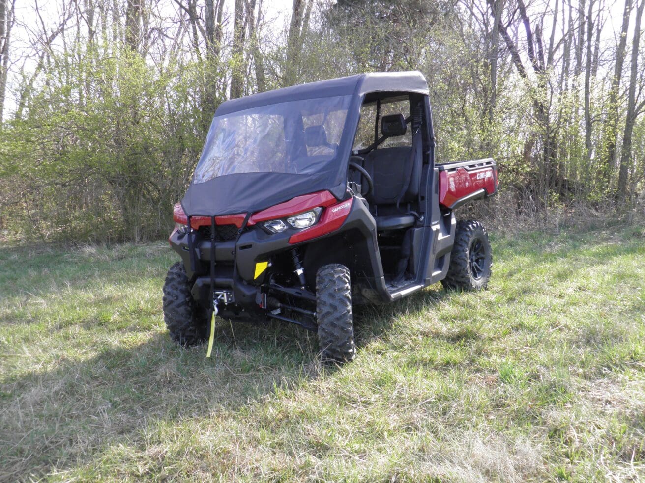 Two-seat red off-road UTV parked in field