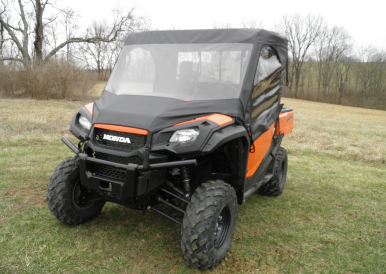 Orange Honda UTV parked on grassy field