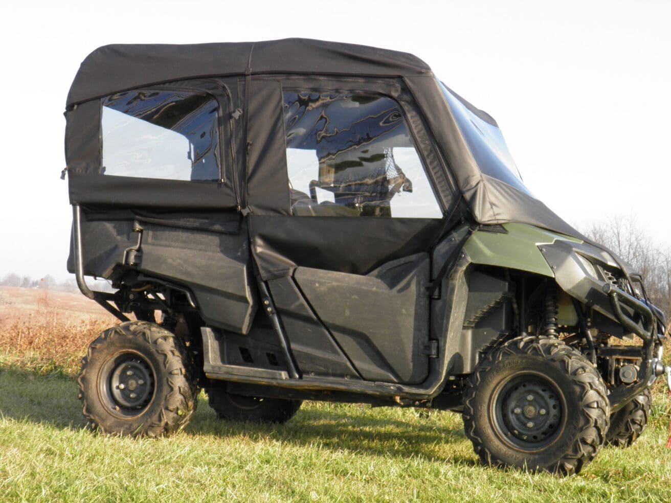 Green side-by-side UTV with soft cab enclosure