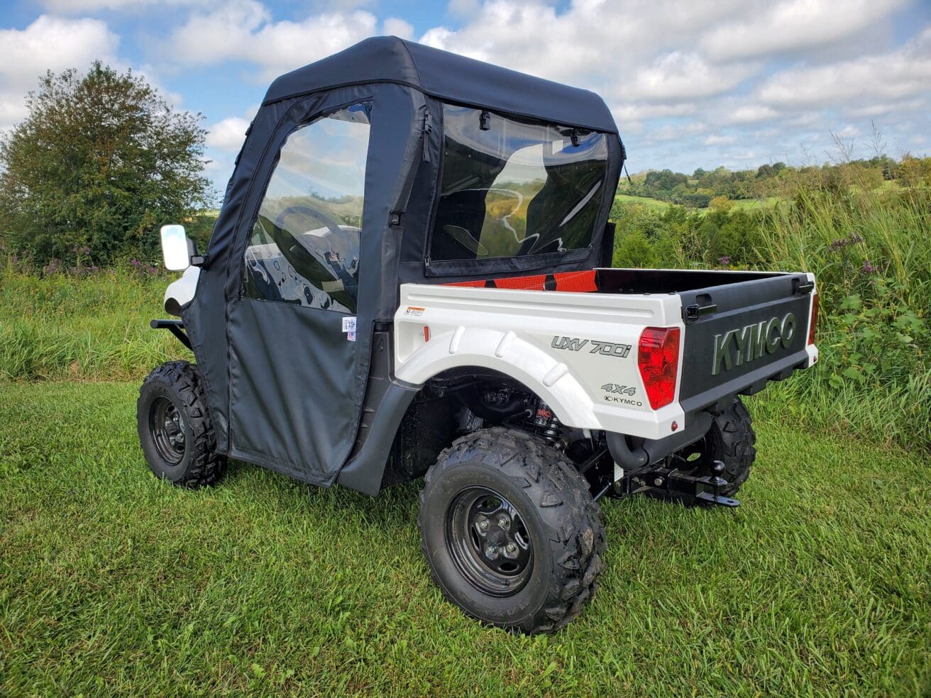 Utility vehicle with soft cab enclosure outdoors.