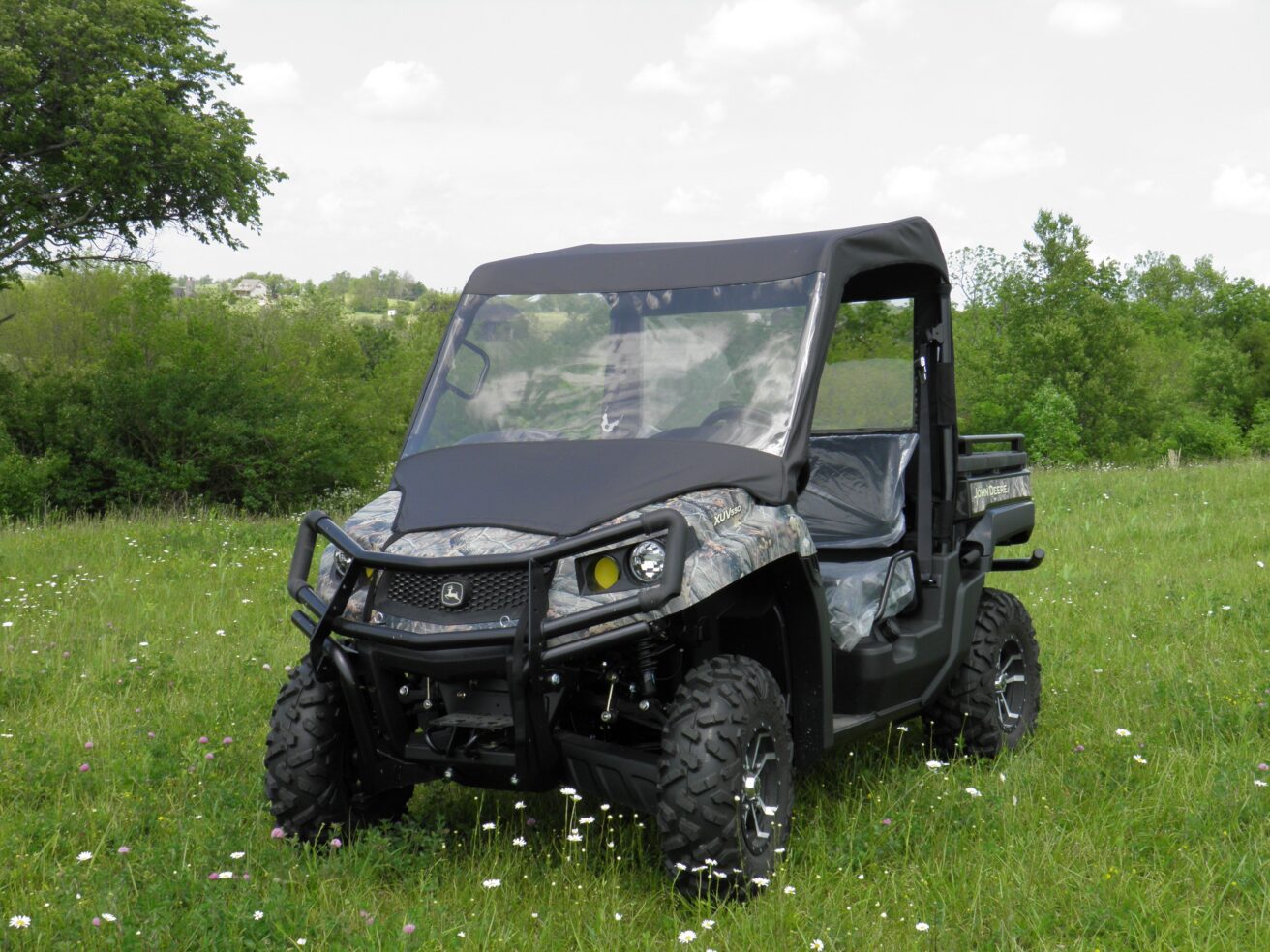Camouflaged UTV parked in grassy field