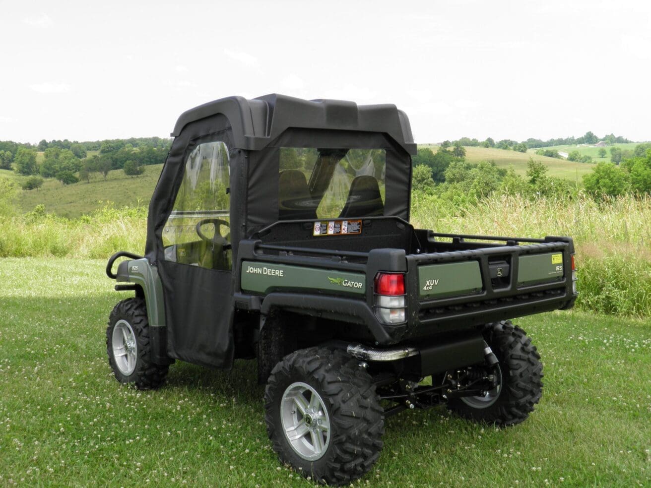 Green John Deere UTV parked on grassy field