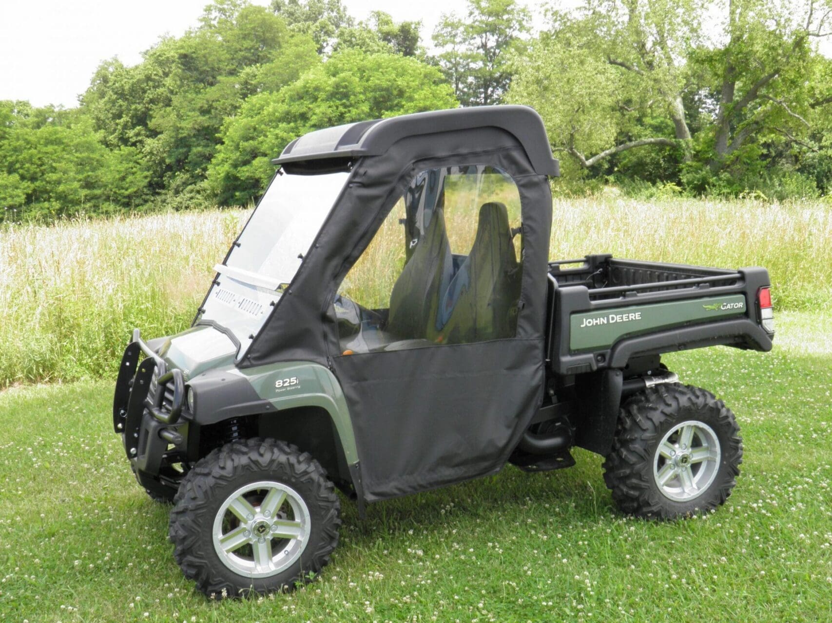 Green John Deere utility UTV parked on grass