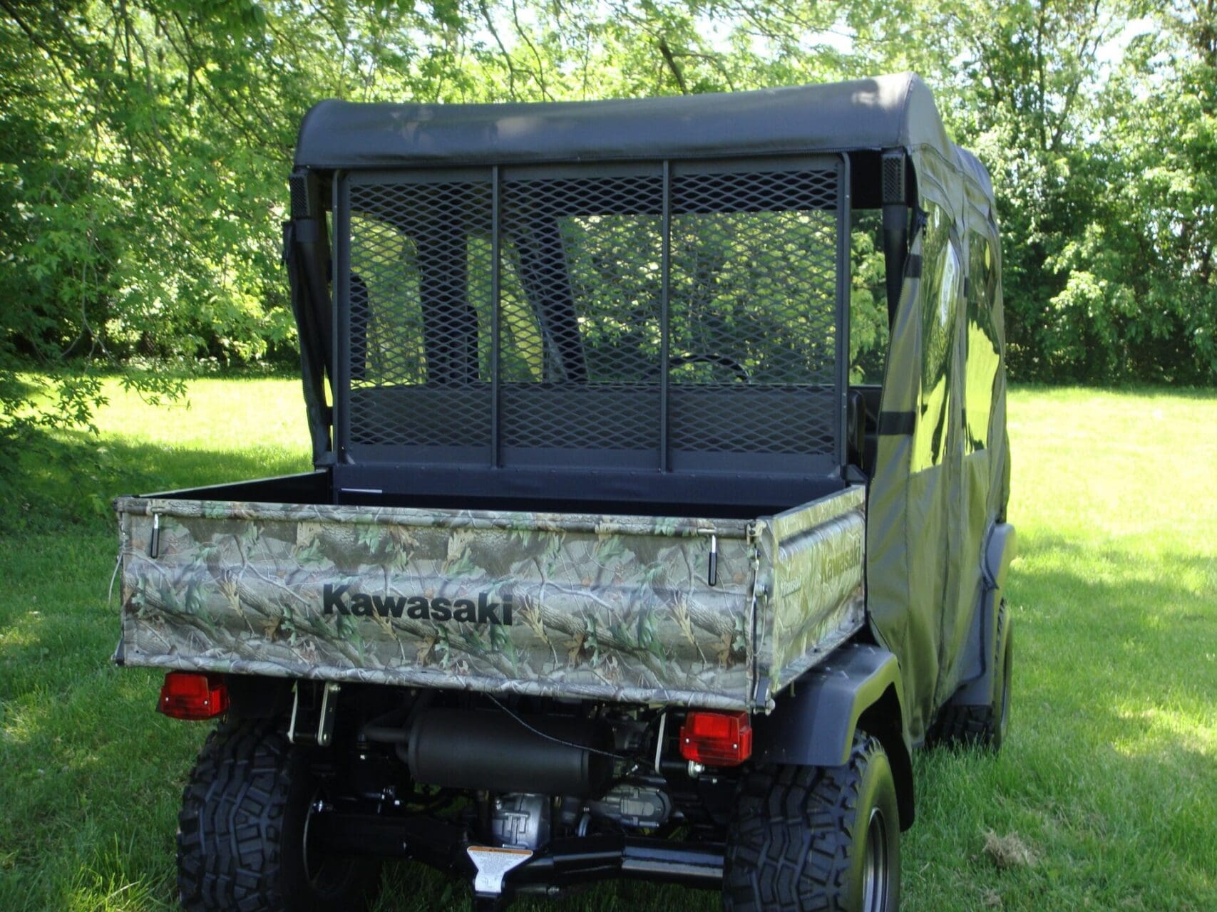 Kawasaki camo utility vehicle parked on grass