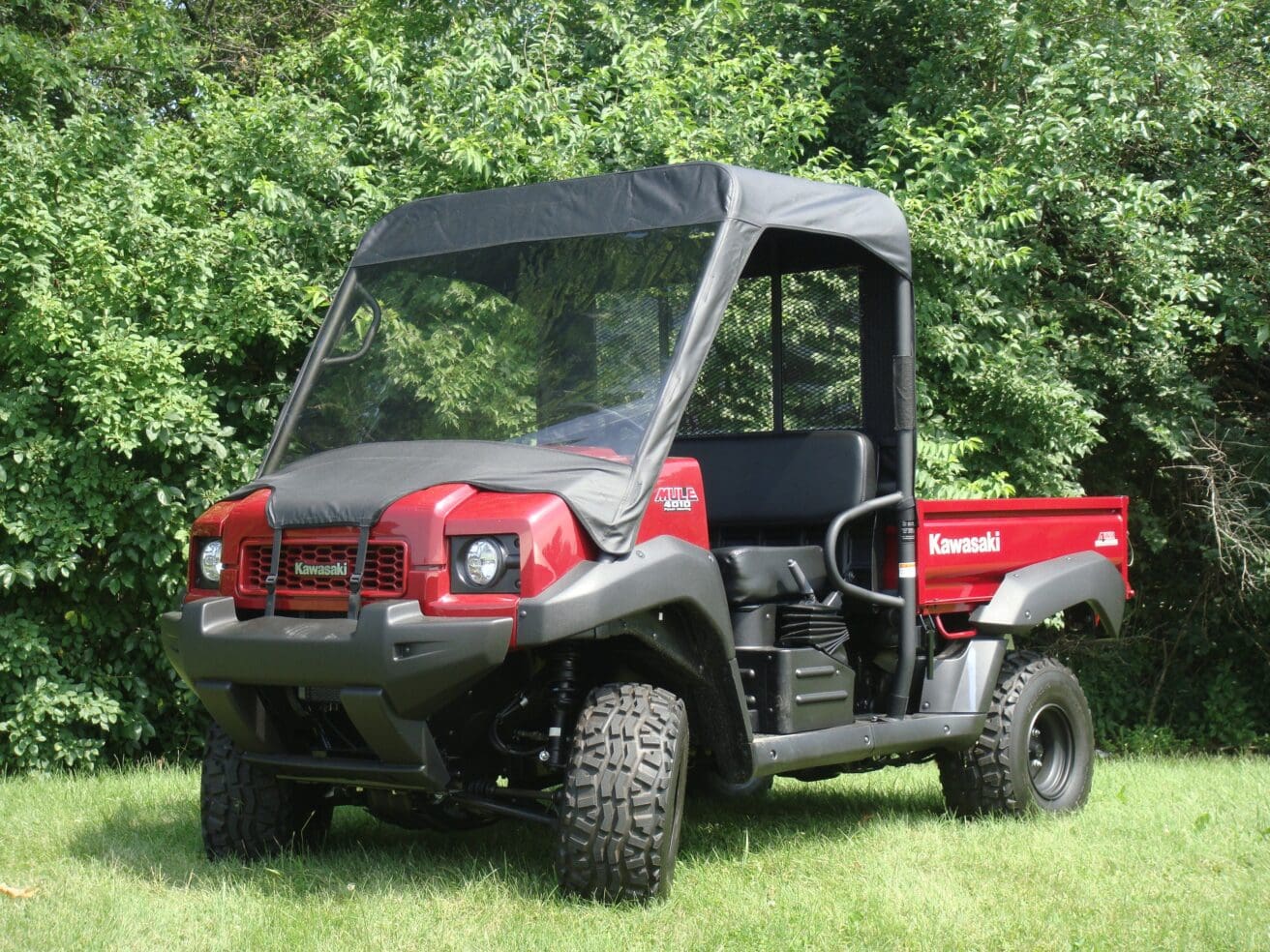 Red Kawasaki utility side-by-side on grass