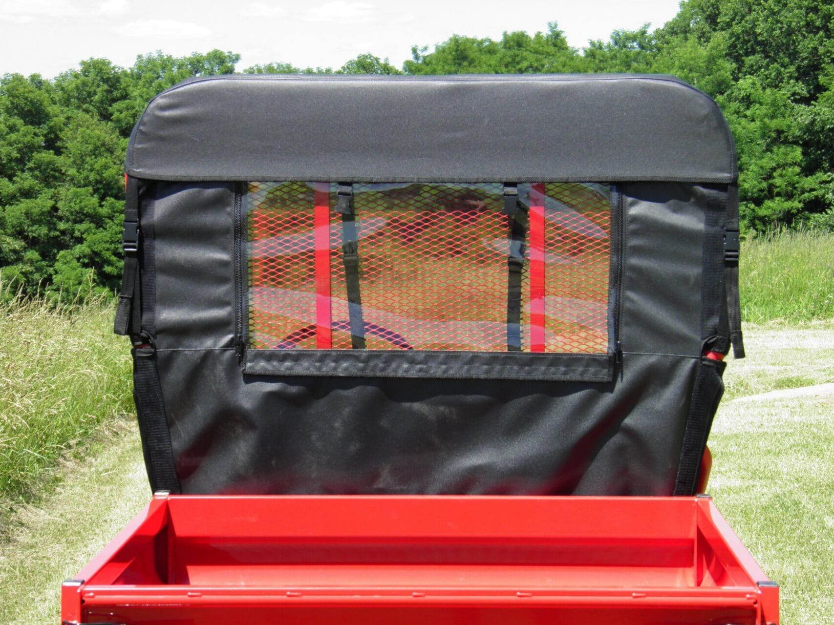 Red utility trailer with black mesh window