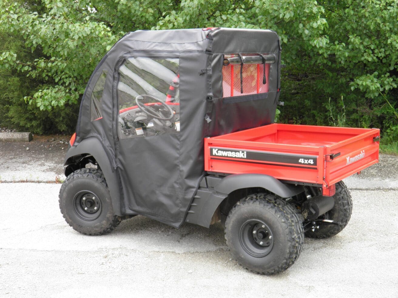 Red Kawasaki 4x4 utility vehicle with cover