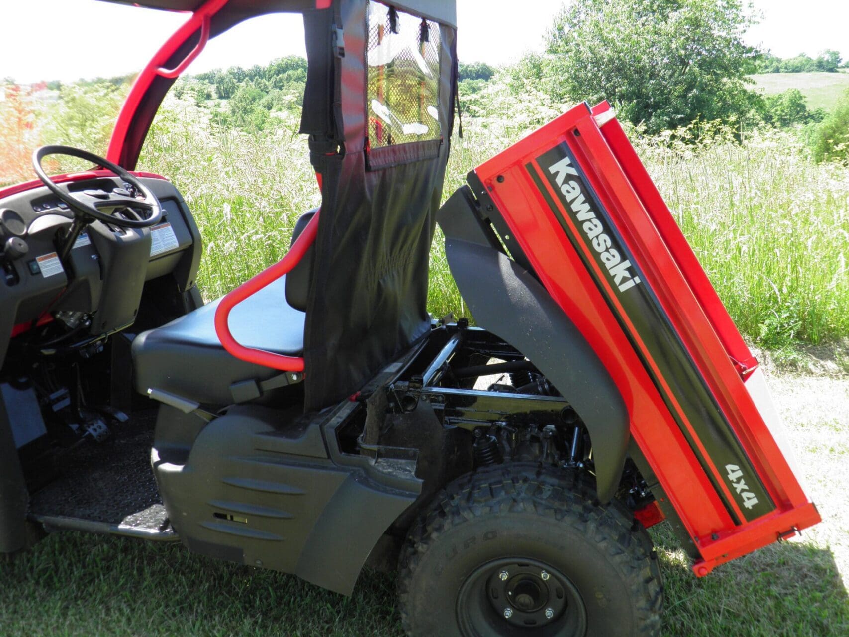 Red Kawasaki 4x4 utility UTV with raised bed