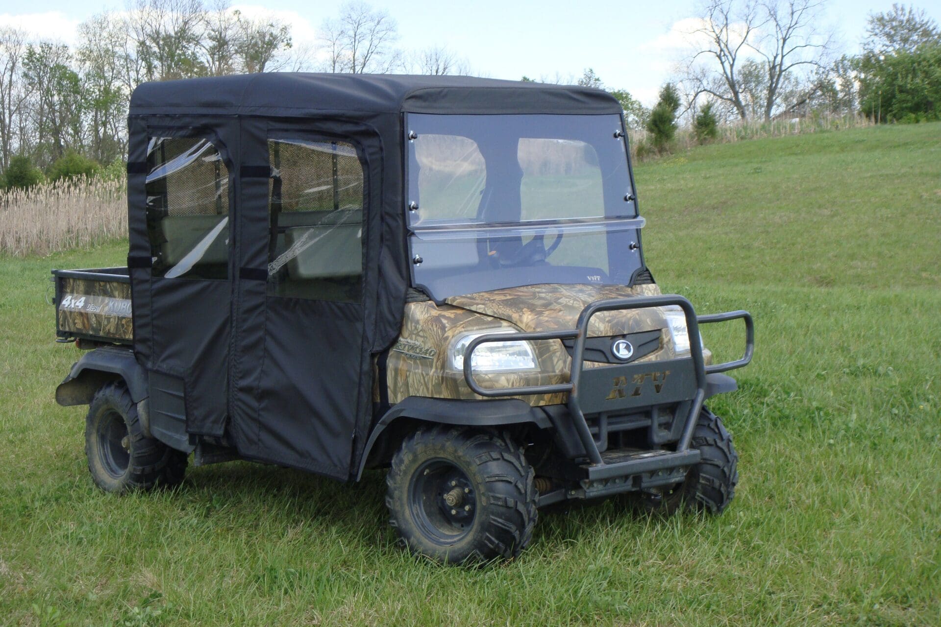Camo utility UTV with soft enclosure on grass