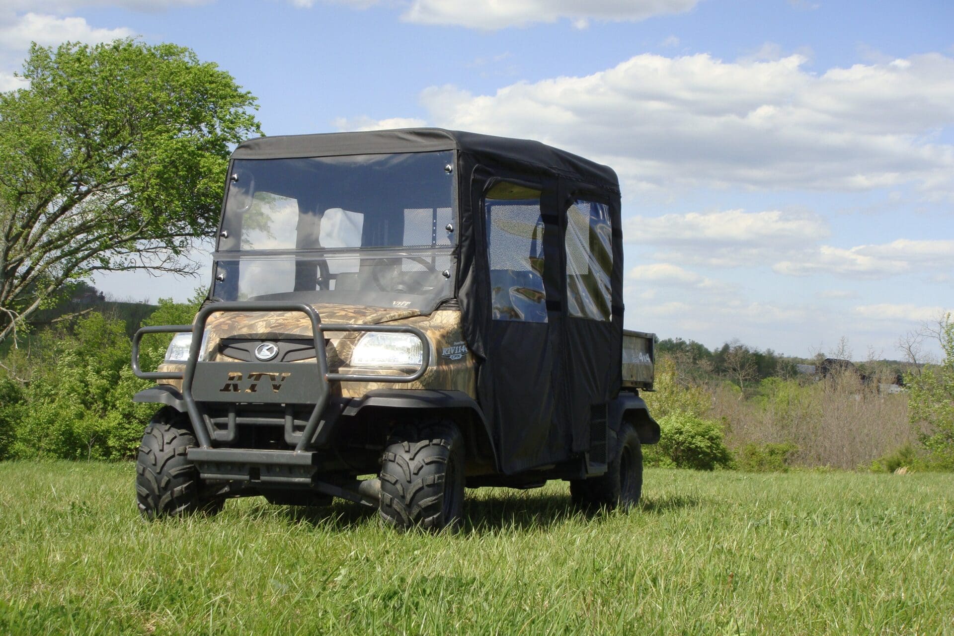 Camouflage utility vehicle parked in grassy field
