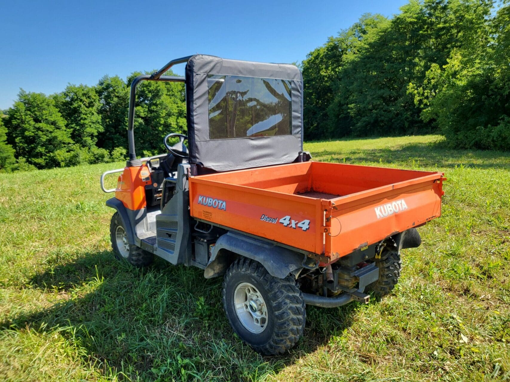 Orange Kubota 4x4 UTV on grassy field