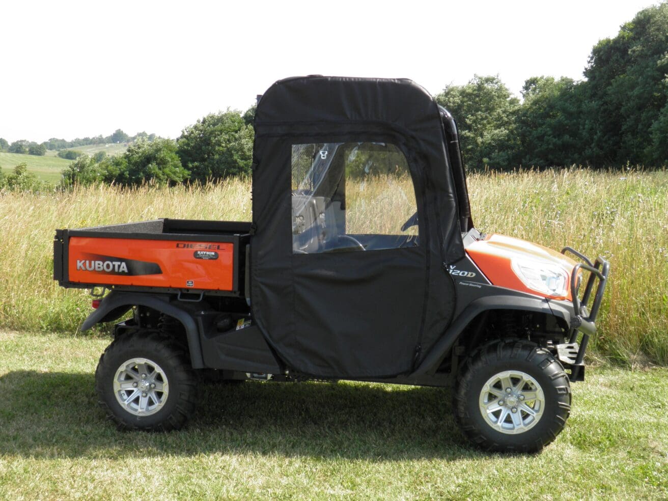 Orange Kubota utility vehicle with enclosed cab