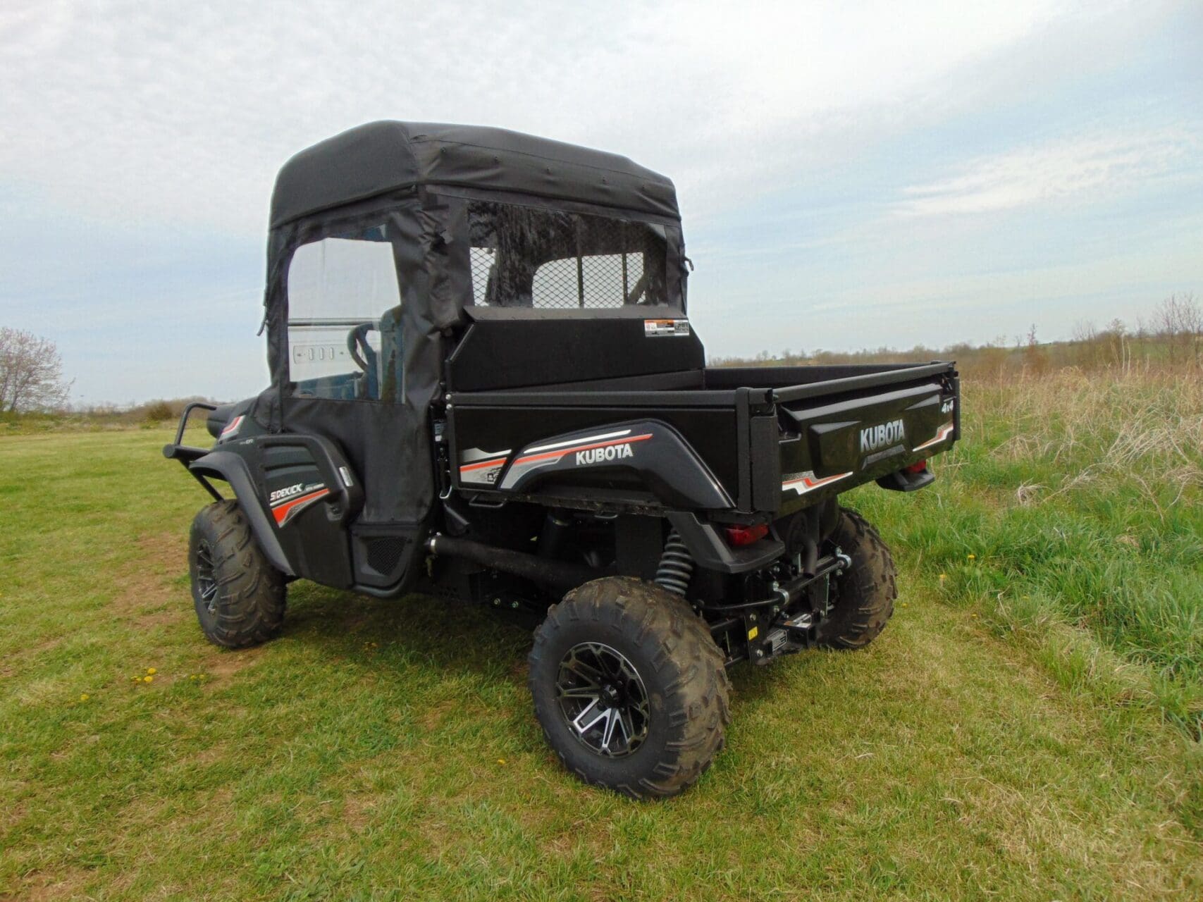 Black Kubota utility UTV parked on grass