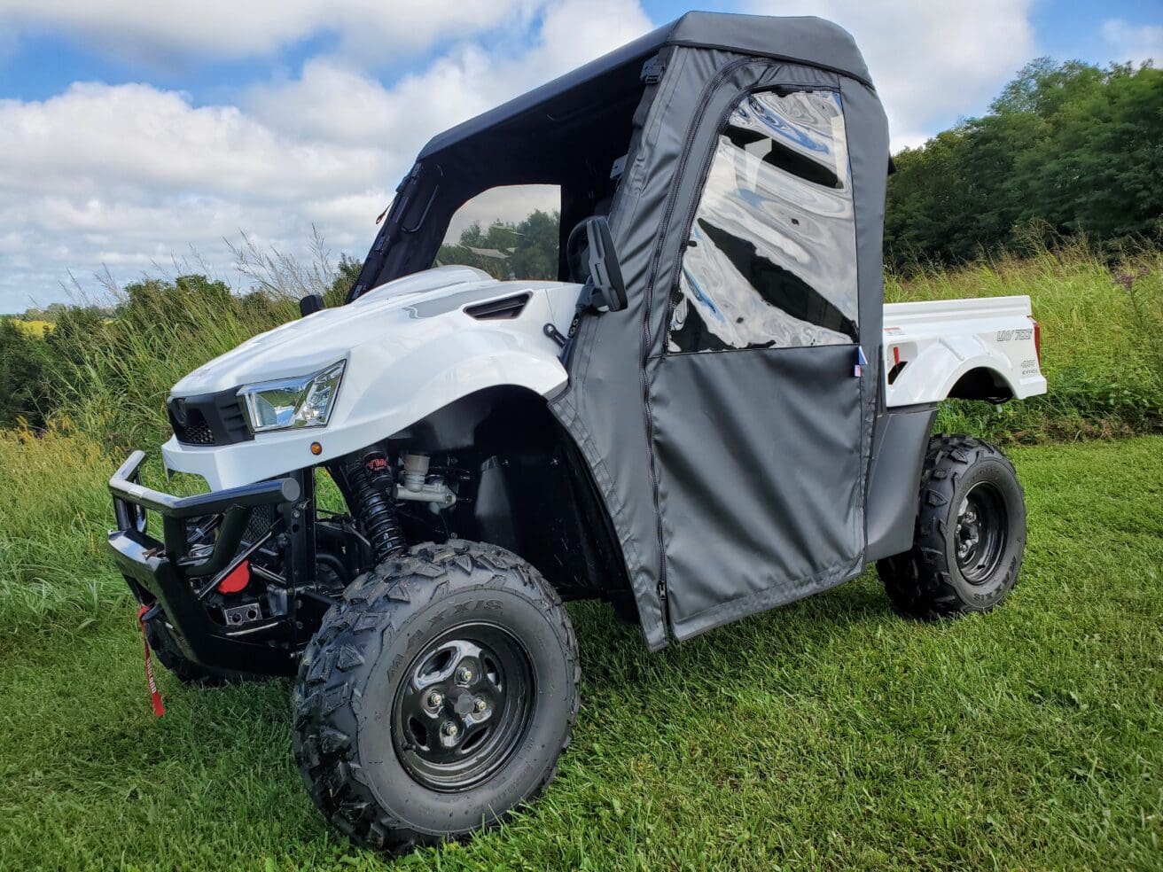 White UTV with soft doors parked on grass