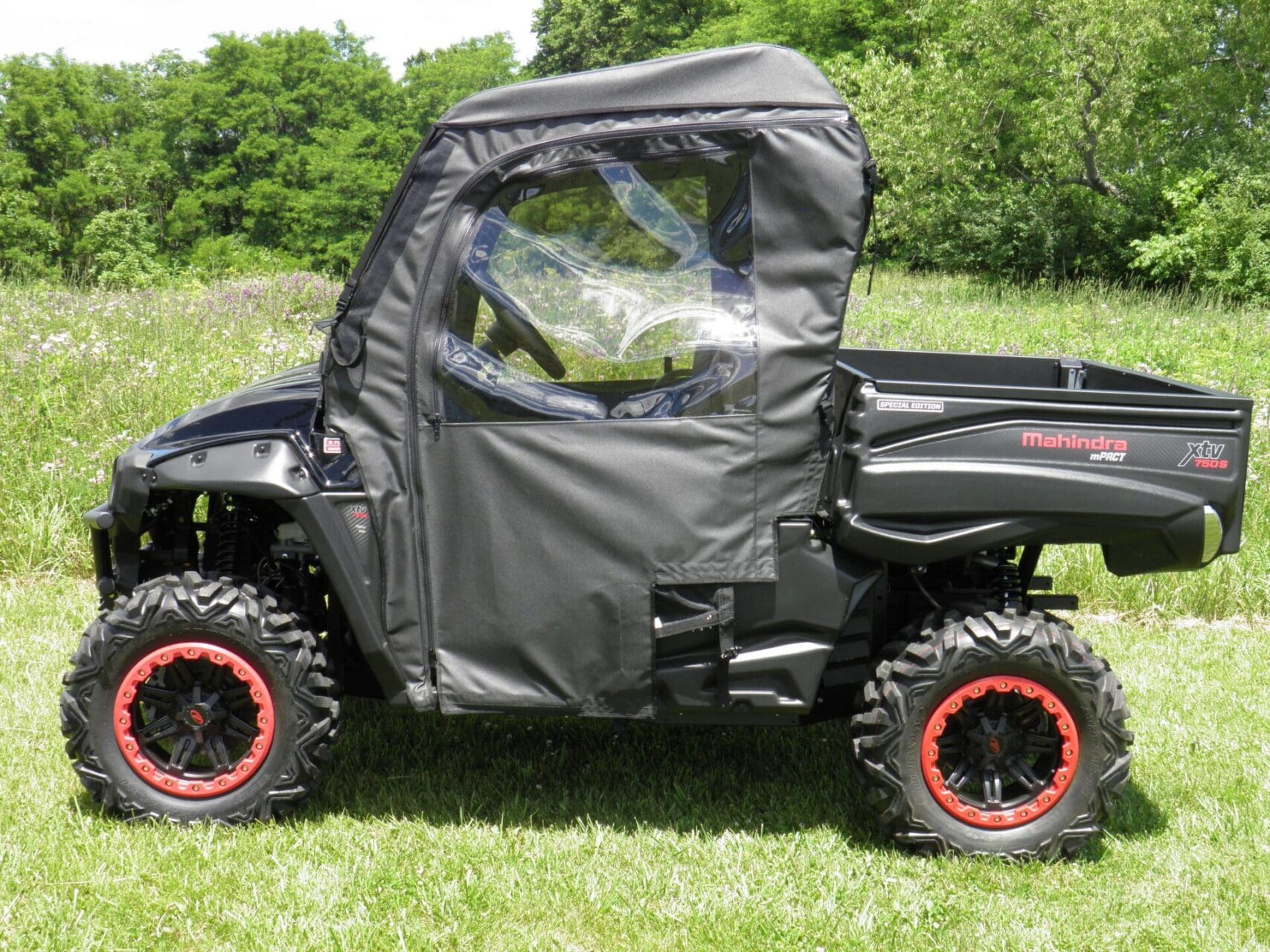 Black Mahindra UTV with red-rim tires