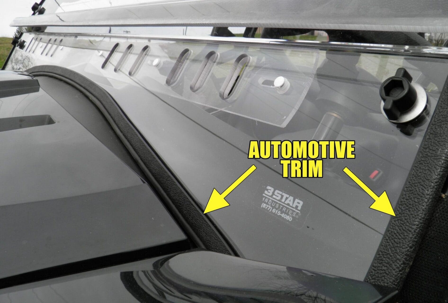 Automotive windshield trim labeled with yellow arrows