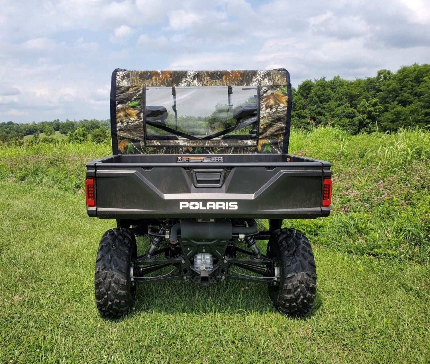 Polaris utility vehicle with camouflage enclosure.