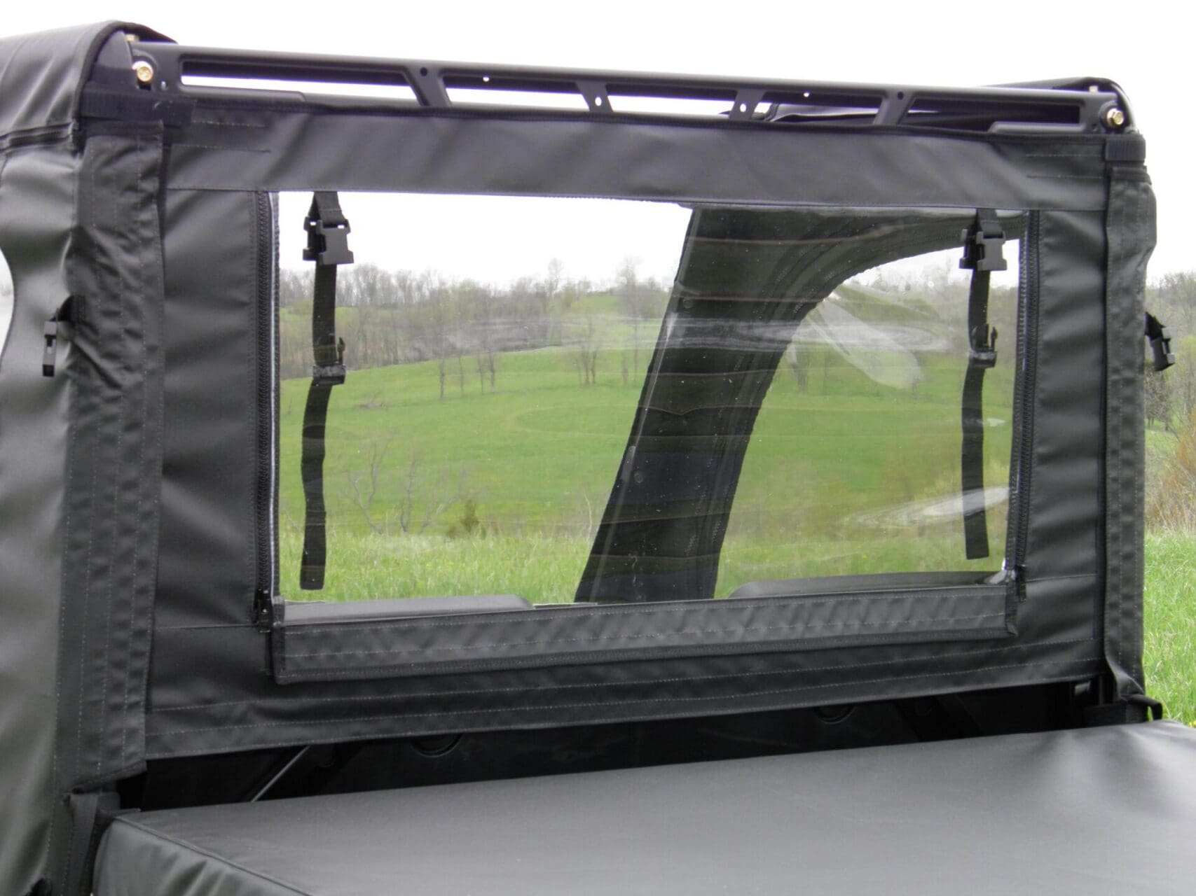 Zippered window panel in vehicle enclosure.