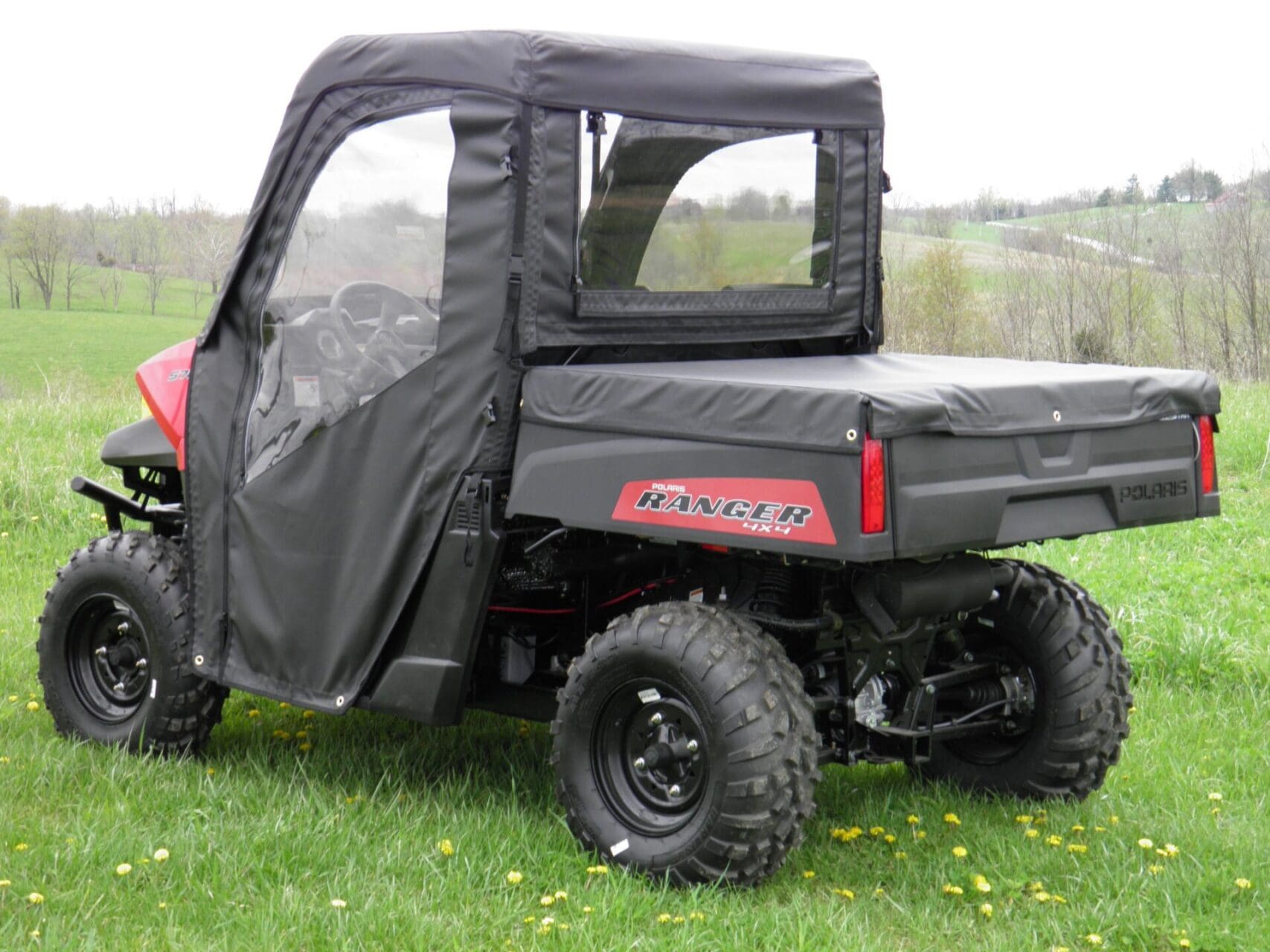 Utility vehicle with protective vinyl enclosure.
