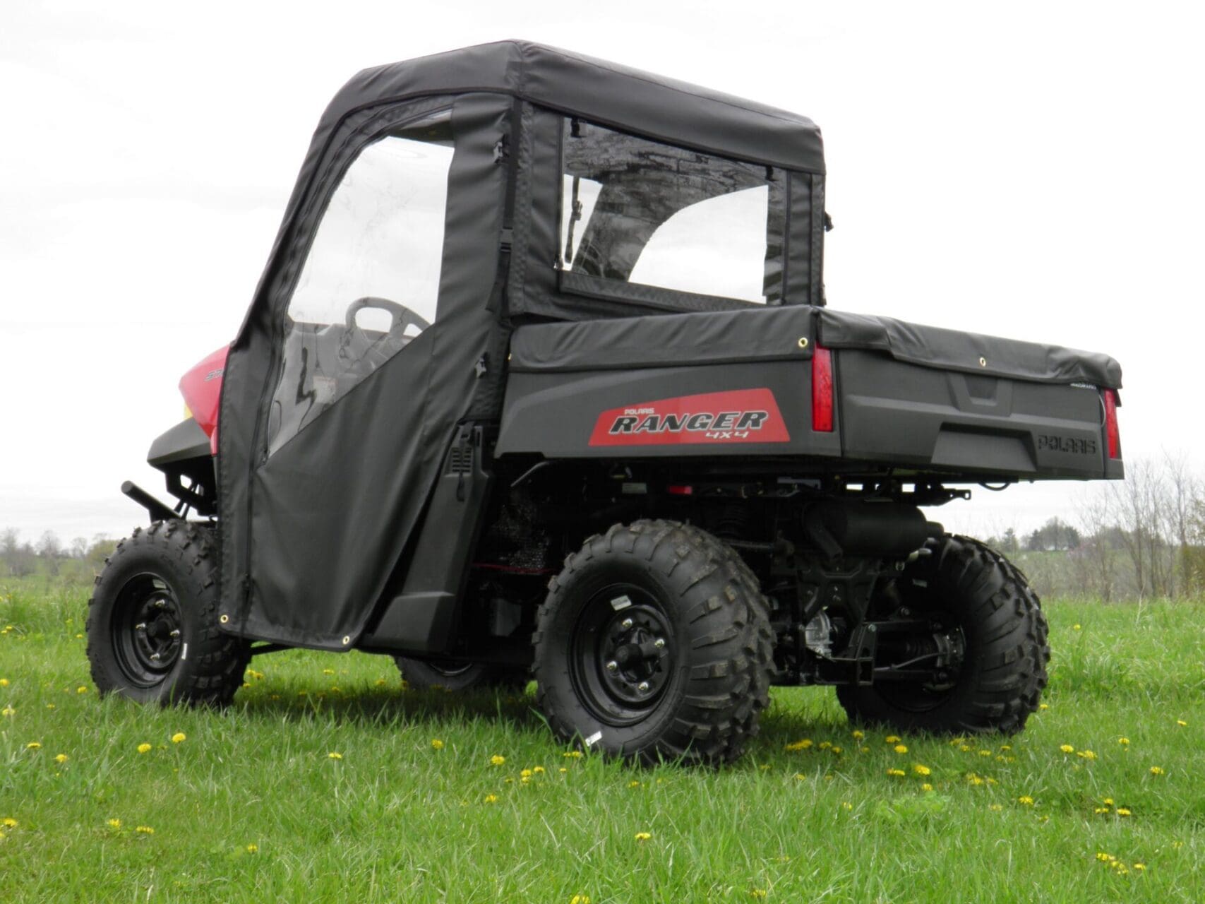 Polaris Ranger with soft enclosure in grass.