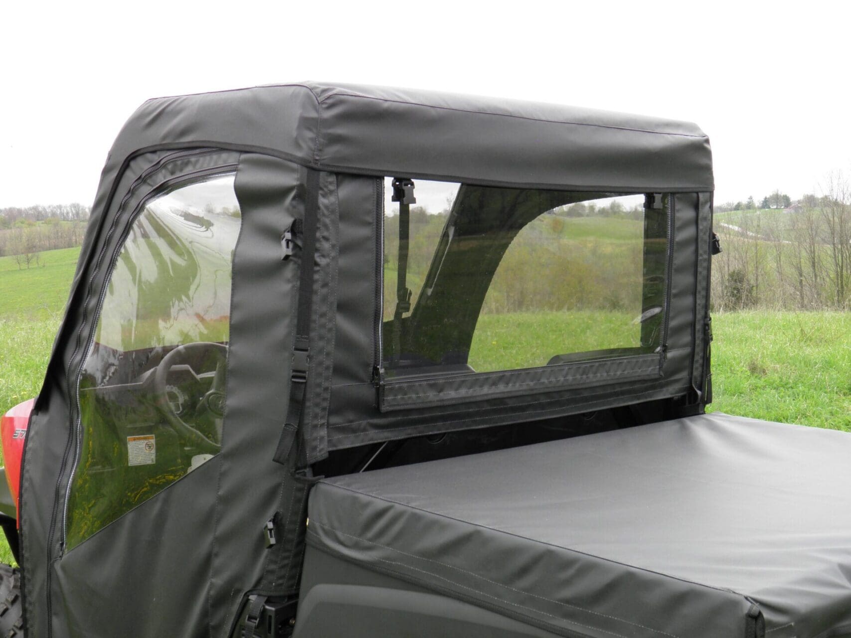 Zippered rear window on black vehicle enclosure.