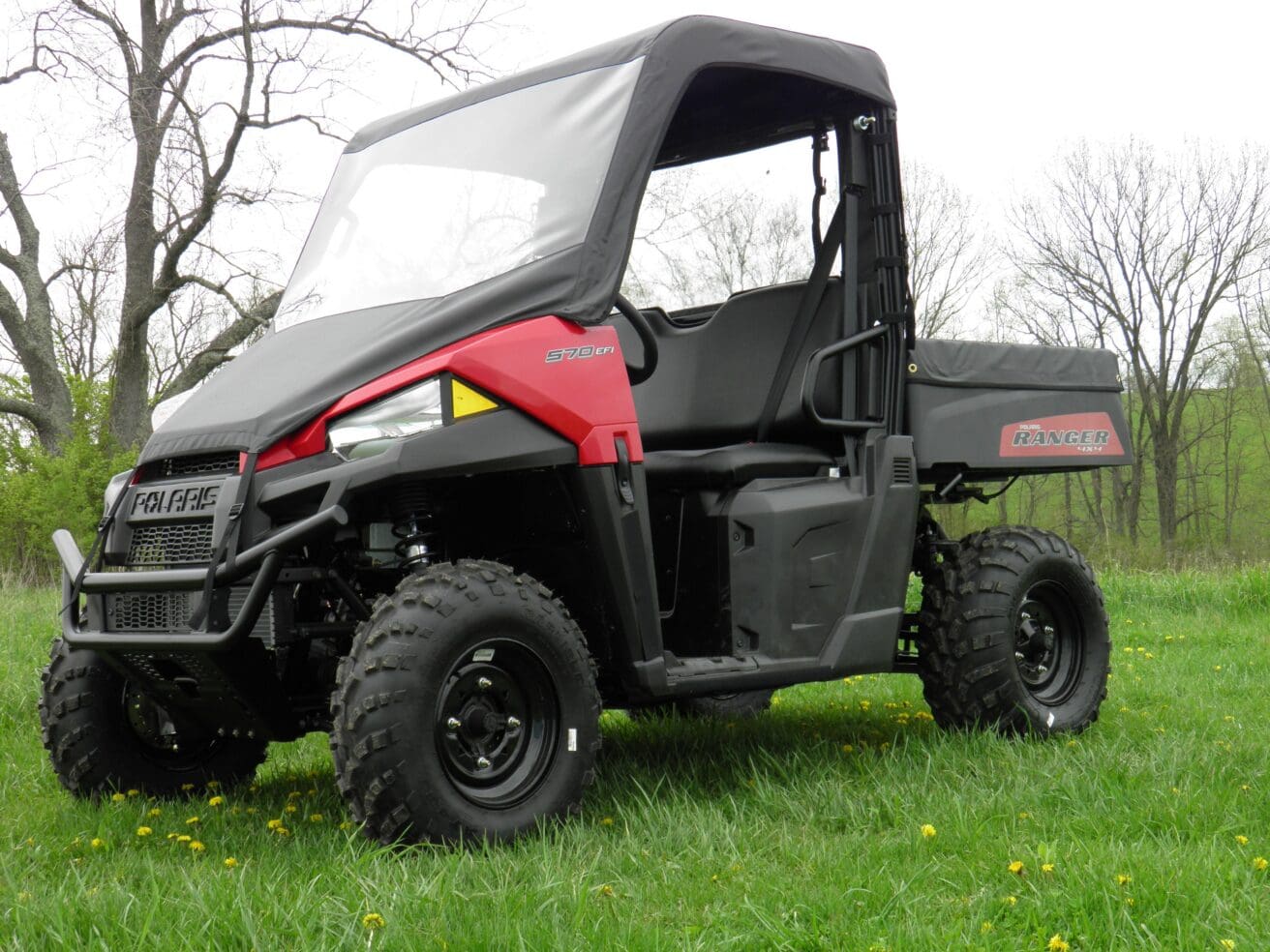 Polaris Ranger parked in grassy outdoor setting.