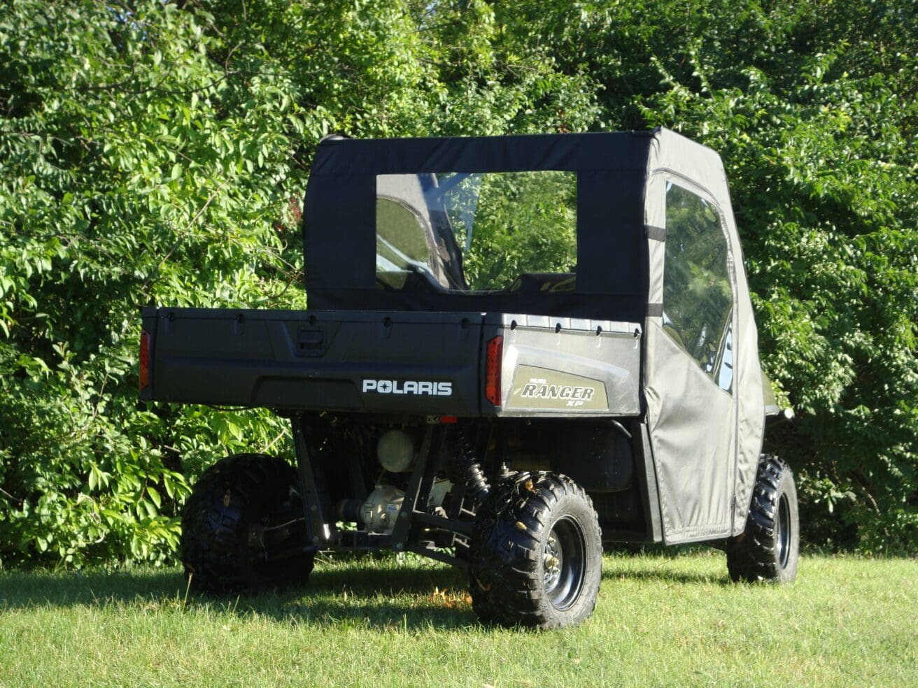 Polaris Ranger with soft enclosure in greenery.
