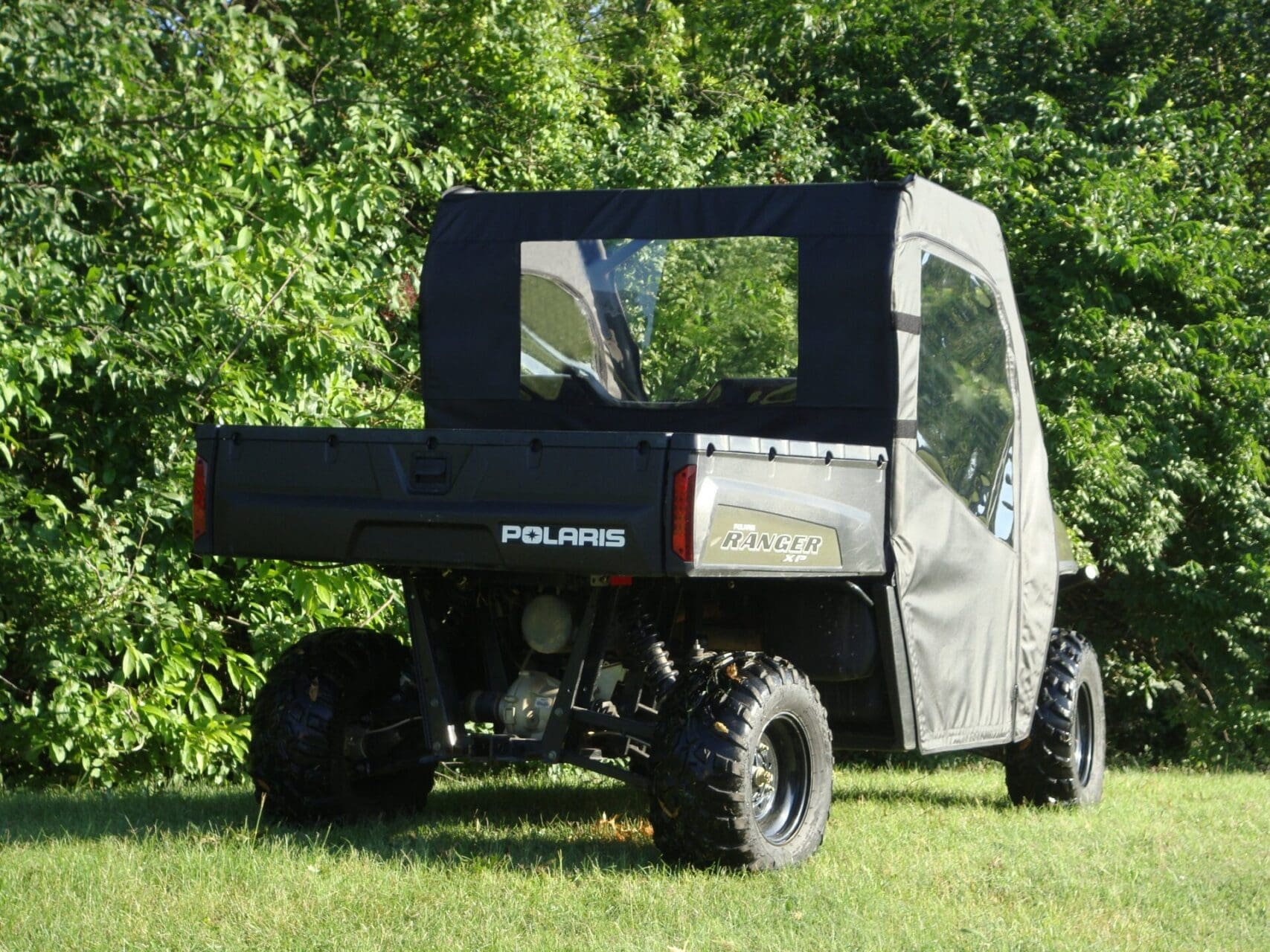 Polaris Ranger with soft enclosure in greenery.