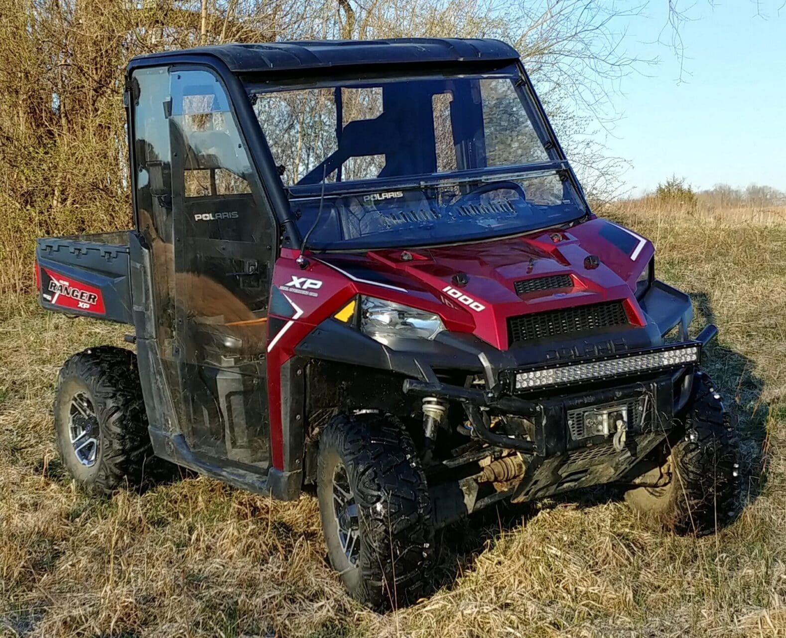 Red Polaris Ranger UTV parked in field