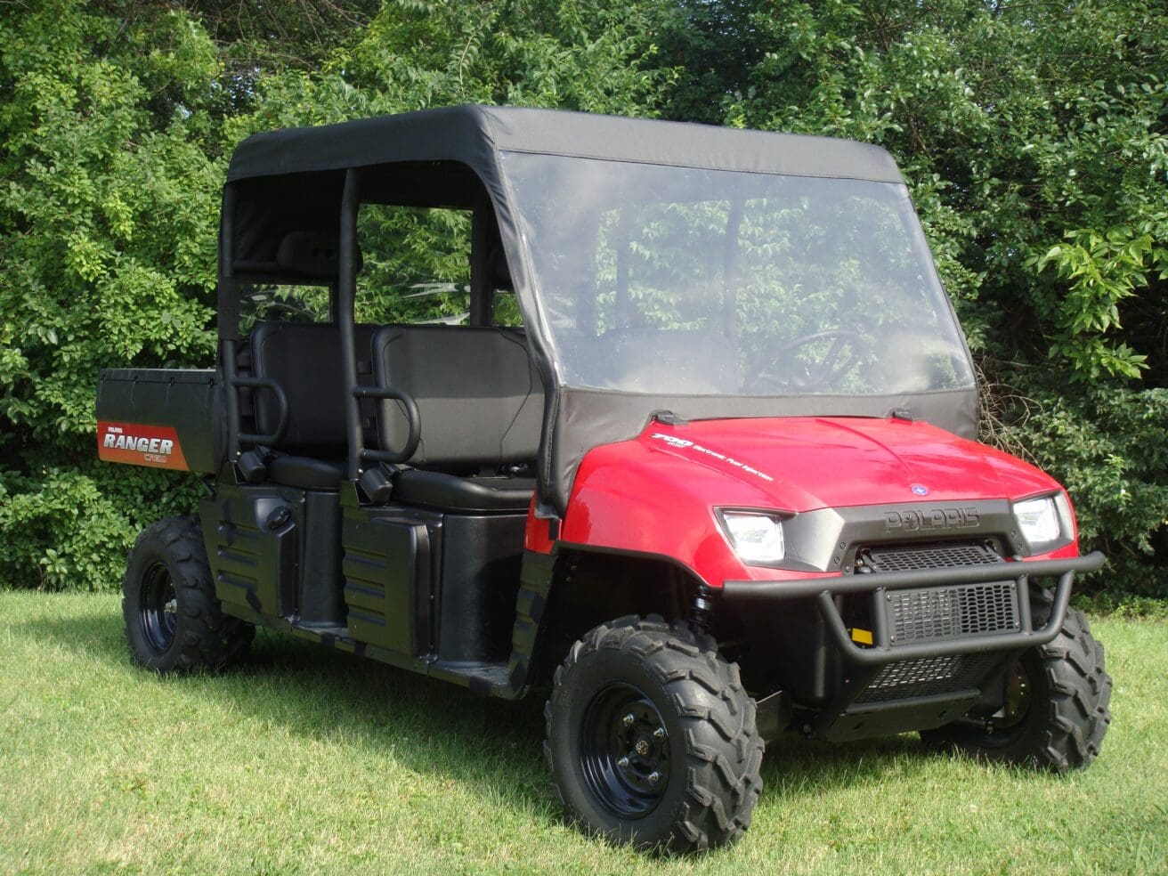 Red utility side-by-side UTV parked on grass