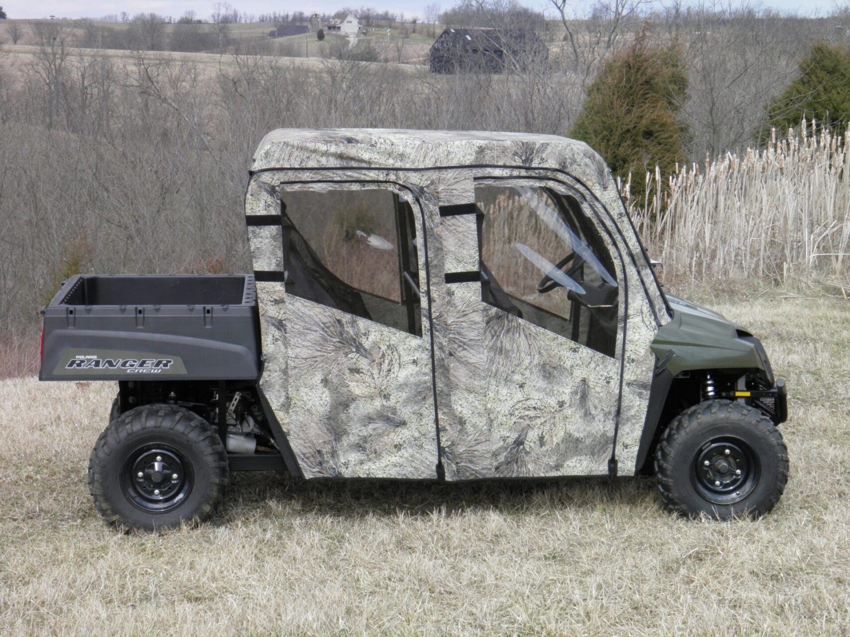 Camouflaged utility vehicle in grassy field