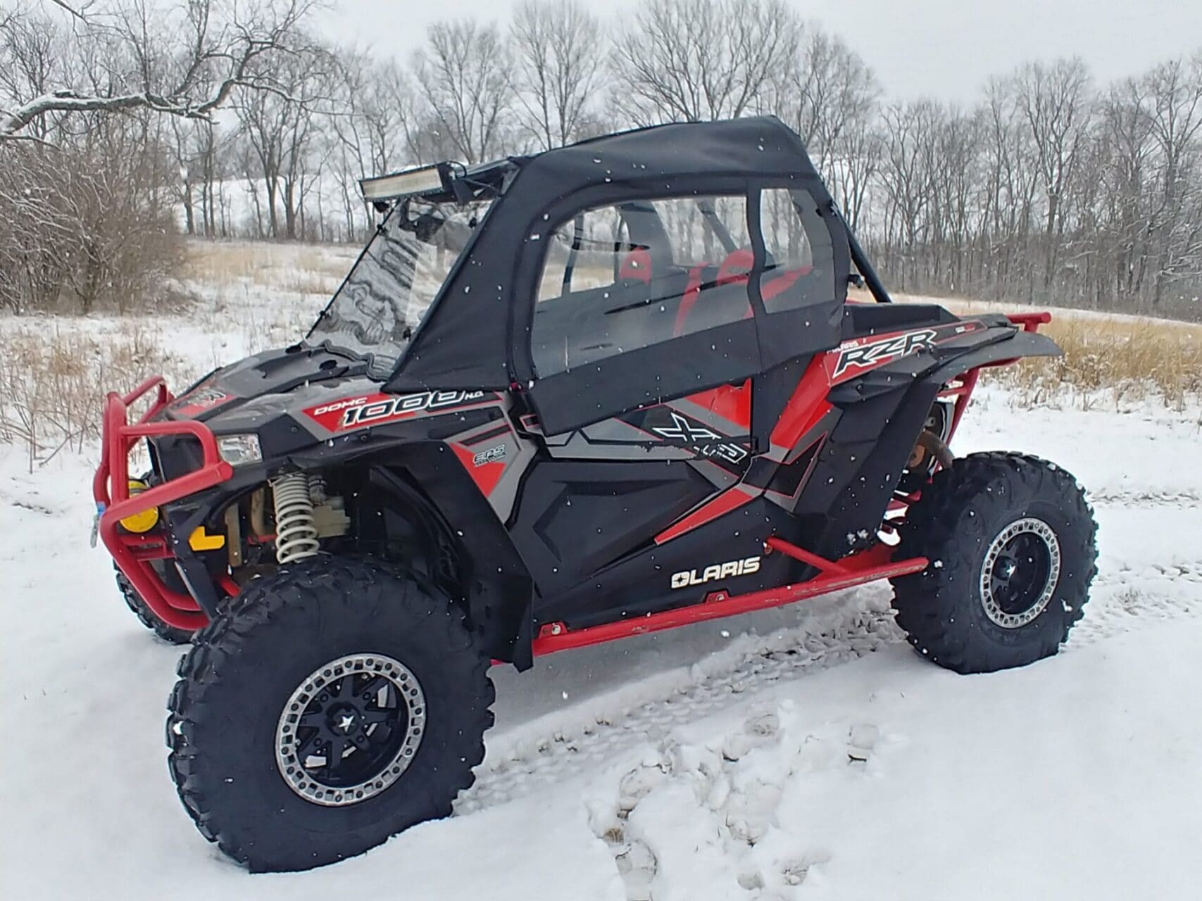 Polaris RZR off-road vehicle parked in snow
