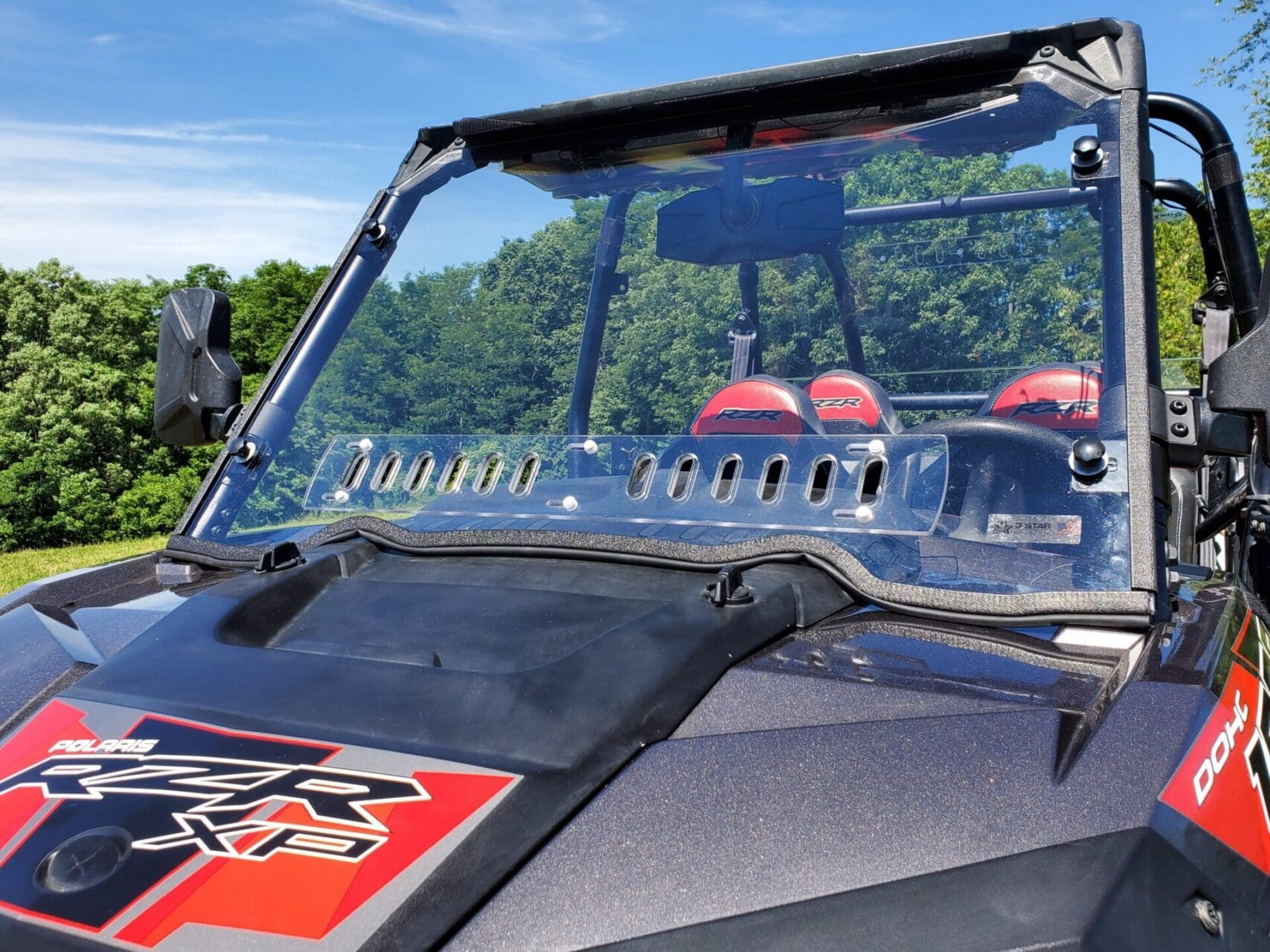 Polaris RZR UTV windshield with red helmets